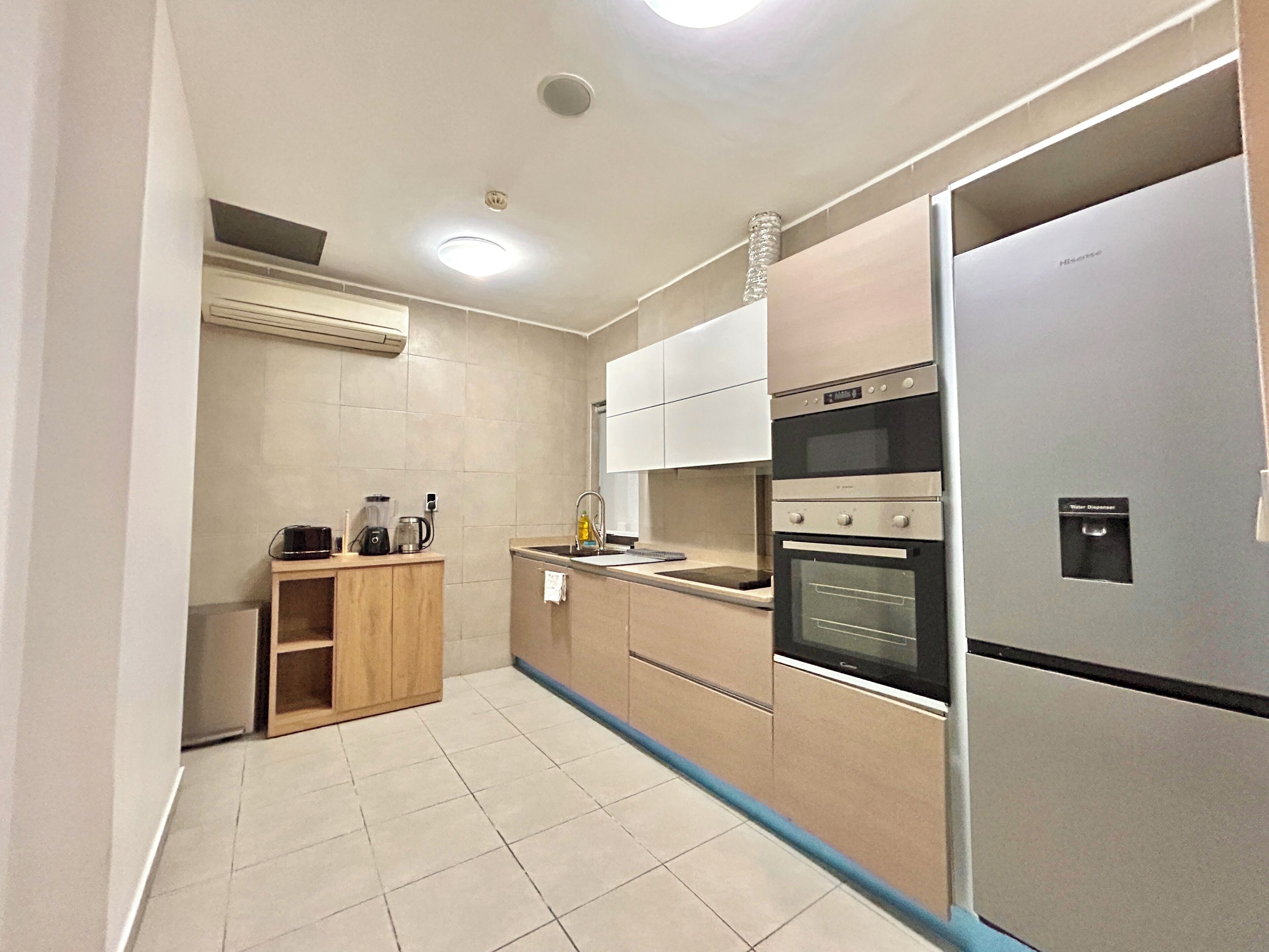 A modern kitchen with a built-in oven, a water dispenser, and a coffee maker.