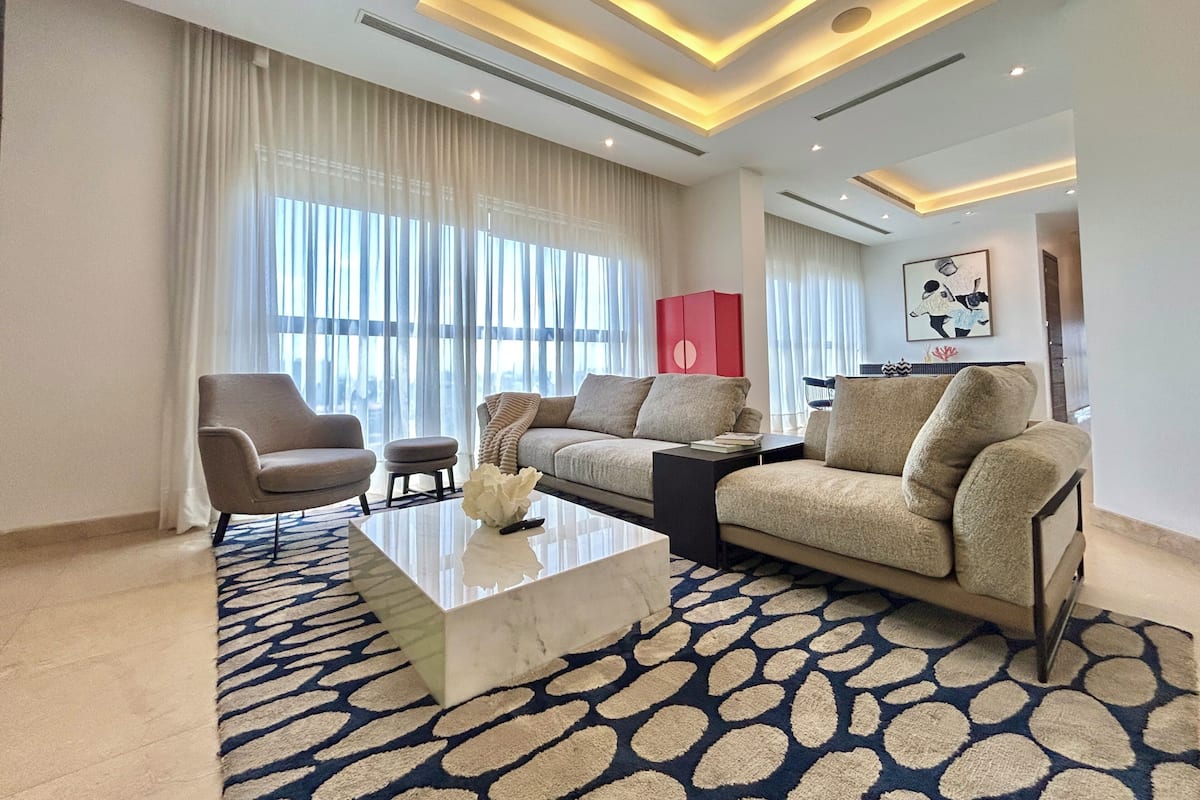 A modern living room with a sofa, armchair, and coffee table.