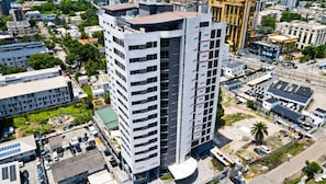 A high-rise building with multiple floors, surrounded by other buildings and greenery. - RIVERRUN RESIDENCE (Lagos)