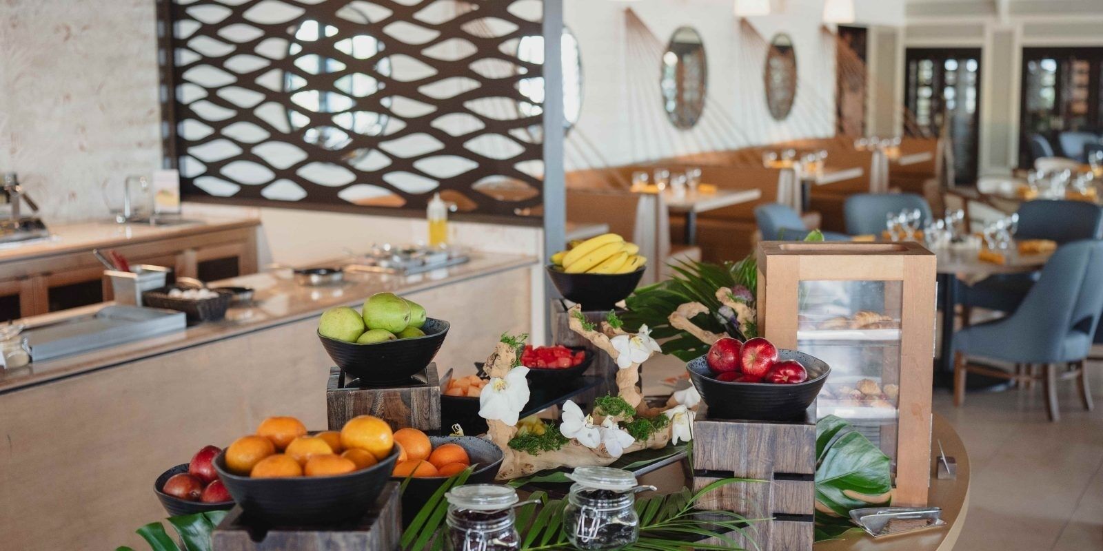 Un buffet garni de divers fruits et agrémenté d’un centre de table décoratif.
