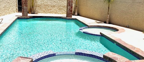 Una piscina al aire libre de temporada, sombrillas