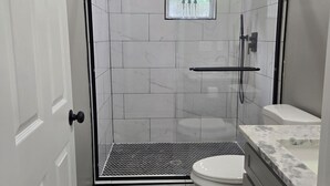 Ein Badezimmer mit Dusche, Toilette und Waschbecken.
