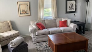 A living room with a sofa, a coffee table, a side table, and a lamp. - Sunny townhome:walk to UD & stadium (Newark)