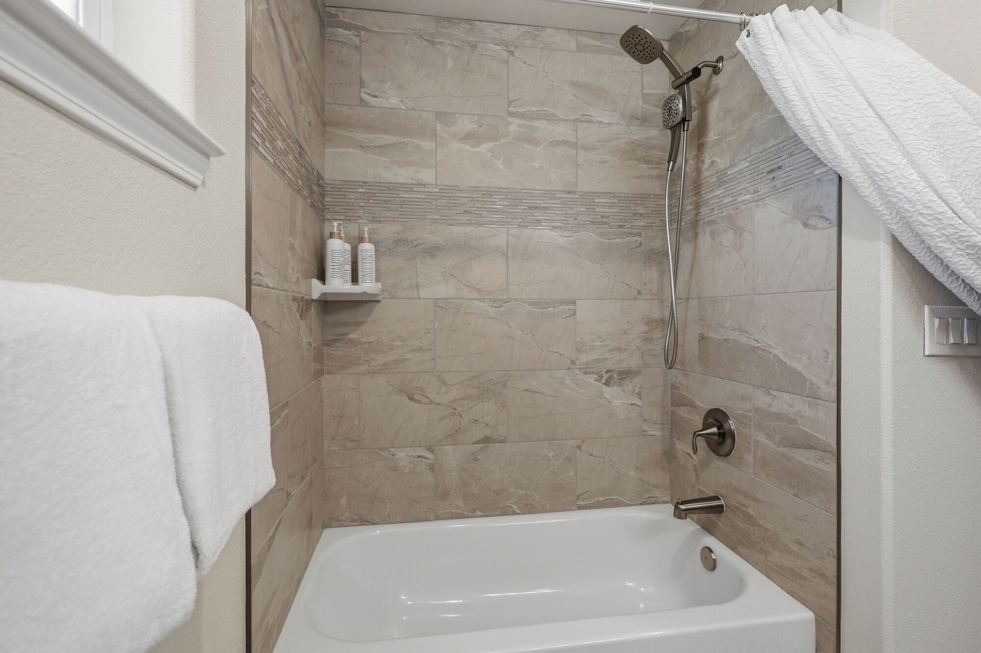 Une salle de bain avec une baignoire, une douche et un porte-serviettes.