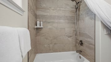 Une salle de bain avec une baignoire, une douche et un porte-serviettes.