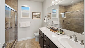 A modern bathroom with a glass shower enclosure, dual sinks, and a large mirror. - Amazing new home- All the Amenities! (Murphys)
