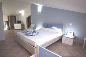 Ein Schlafzimmer mit Bett, Nachttischen, einem Schminktisch und einem Fernseher.