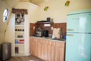 Een koffiezetapparaat/waterkoker, een koelkast, een kookplaat