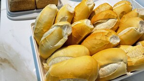 Um buffet com diversos produtos de panificação, incluindo pães e doces.