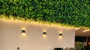 Uma área de recepção com uma parede verde, um balcão com micro-ondas e quadros pendurados na parede.