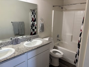 A bathroom with two sinks, a toilet, a shower, and a bathtub. - Awesome 3-bedroom house with AC in pleasant Kingman (Kingman)