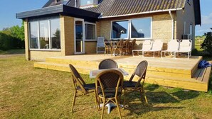 A modern house with a deck, large windows, and outdoor furniture. - 5 Star Holiday Home in Femo (Maribo)