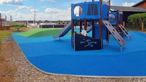 A playground with a slide, climbing area, and a ship-themed play structure. - 5 Star Holiday Home in Femo (Maribo)