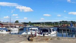 A marina with boats docked, a clear sky, and a distant building. - 5 Star Holiday Home in Femo (Maribo)