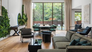 A modern living room with a green sofa, a dining table with chairs, and a pool table. - Eden Luxury in Miami Design District, BBQ & Pool (Miami)