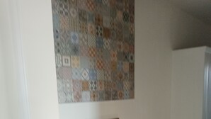 Eine Treppe mit weißer Handlauf, einer grünen Wand und einer Wandverkleidung mit Muster.