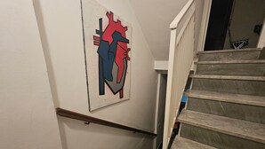 Un escalier doté d’une rampe et orné d’une œuvre d’art murale représentant un cœur stylisé.