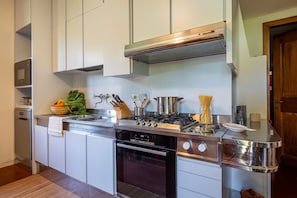 A modern kitchen with stainless steel appliances, a built-in oven, and a gas stove. - Villa Collegigliato 8, Emma Villas (Pistoia)