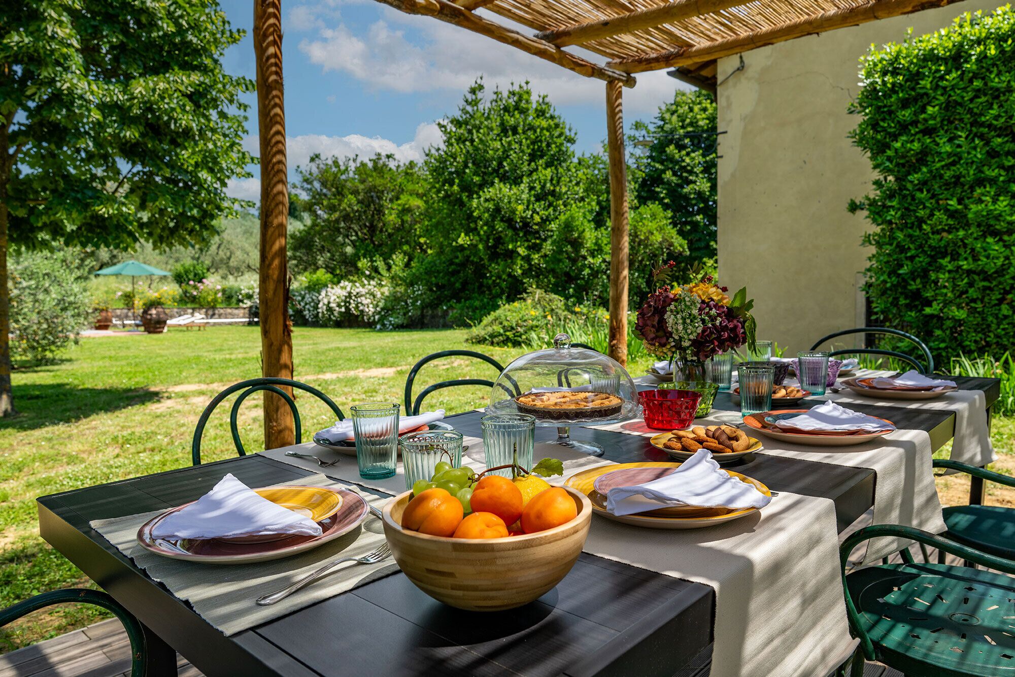 Un espacio de comedor al aire libre con mesas, sillas y una variedad de alimentos y bebidas.