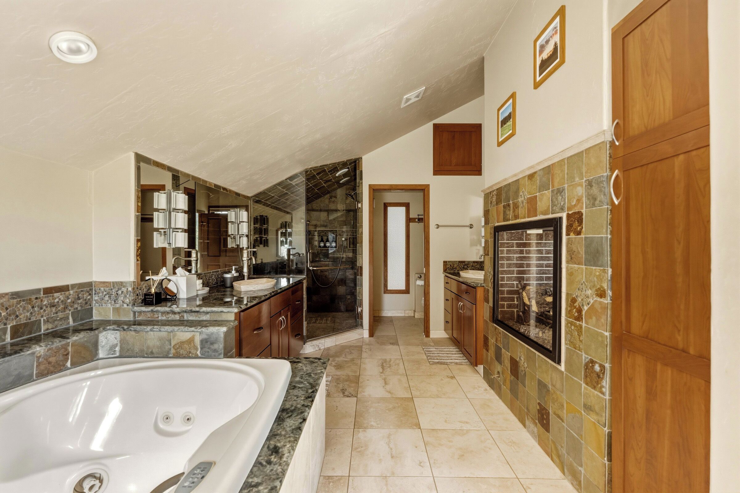 Ein geräumiges Badezimmer mit einer großen Badewanne, einer separaten Duschkabine und einem Waschtisch.