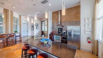 A modern kitchen with a central island, stainless steel appliances, and a decorative backsplash.