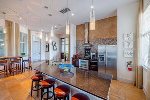 A modern kitchen with a central island, stainless steel appliances, and a decorative backsplash. - Landing | Amazing 2BD, Courtyard, Pool (Cedar Park)