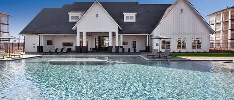 A large building with a swimming pool in front.