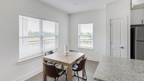 Eine moderne Küche mit einer Granit-Arbeitsplatte, weißen Schränken und einem Edelstahl-Kühlschrank.