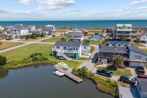 A coastal residential area with houses, a dock, and a body of water.