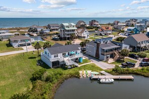 A coastal residential area with houses, a dock, and a body of water. - Helluva View–3BR waterfront home,  beach days, poolside nights, endless sunsets. (North Topsail Beach)