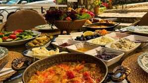 Una mesa con diversos platos, un coche y un cartel que dice 'DEIGE' al fondo.
