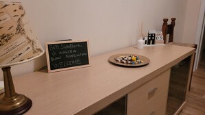 A wooden counter with a chalkboard sign, a plate of snacks, a lamp, and a calendar. - Nice house (Taranto)