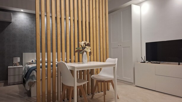 A modern bedroom with a bed, bedside table, lamp, and a TV. - Apartment that still smells new,opening in April,20 minutes from the city center (Palermo)