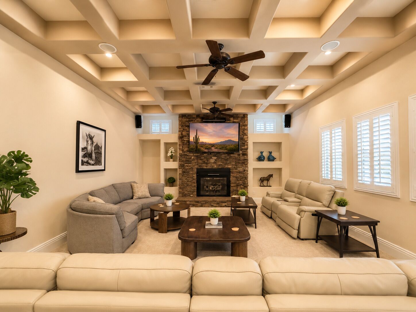A living room with a fireplace, sofas, a coffee table, and a ceiling fan.