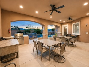 An outdoor patio area with a pool, seating, and a grill. - Exquisite 9BR/5BA Villa - Sports Court, Game Room, Movie Room, Pool, & Spa ★★★★★ (North Las Vegas)