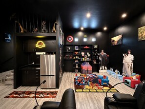 A room with a kitchen area, a seating area with a Star Wars-themed rug, and shelves with collectibles. - Exquisite 9BR/5BA Villa - Sports Court, Game Room, Movie Room, Pool, & Spa ★★★★★ (North Las Vegas)