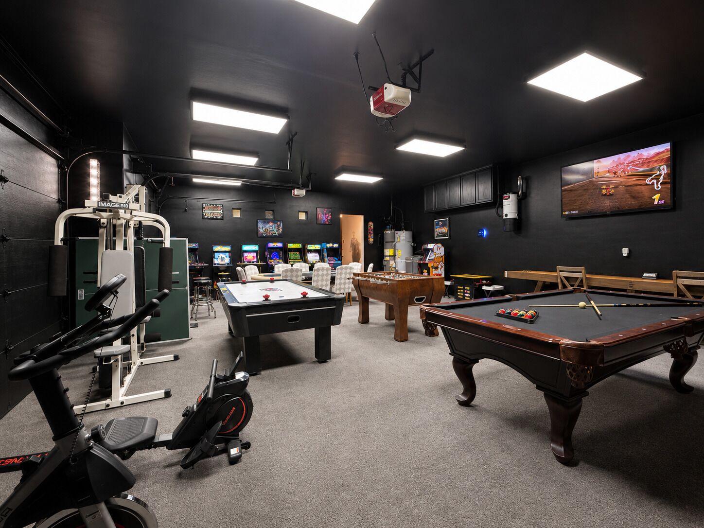Une salle de loisirs équipée d’une table de billard, d’un baby-foot, d’appareils de musculation et de jeux d’arcade.