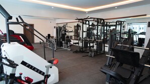 Ett gym med olika typer av träningsredskap, ett löpband och en motionscykel.