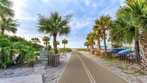A pathway leading to a beach with palm trees and a signboard. - Coligny Beach Villa | Walk Everywhere | Family Favorite (Hilton Head Island)