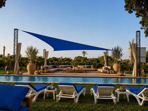 A poolside area with lounge chairs, a large umbrella, and a seating area with cushions. - Palm Oasis Estate Dar Bouazza – 2 Private Villas • 16 Guests • 25m Swimming Pool (Tamaris)