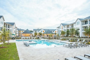 A residential building complex with a central swimming pool, lounge chairs, and a well-maintained lawn. - Landing | Modern 2BD, Clubhouse, Gym (Vestavia Hills)