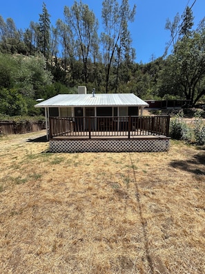 A single-story building with a metal roof and a fenced deck area.