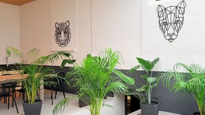 A modern interior with a wooden ceiling, potted plants, and geometric wall art.