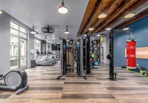 Ein Fitnessstudio mit Laufbändern, Kraftgeräten und einem Schlagring.