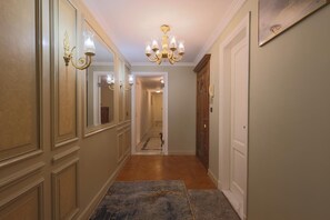 A hallway with a chandelier, a mirror, and a door. - Nile front view & pyramids too.3 master BR+maid room.Large classy fully equipped (Cairo Governorate)