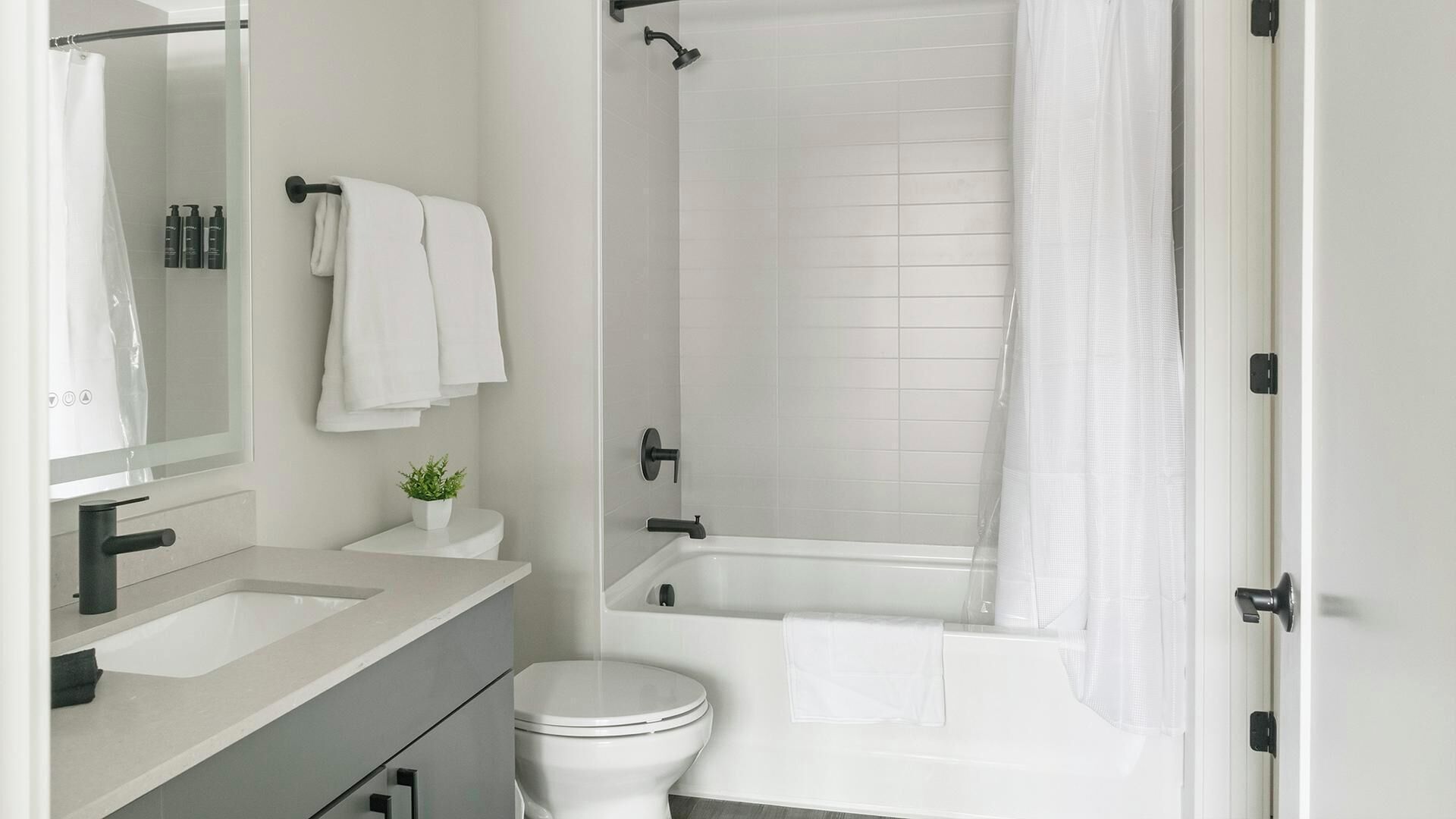 Un baño moderno con inodoro, lavamanos y bañera.