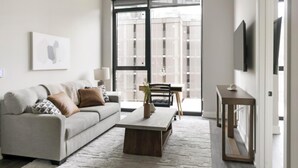 Un salon moderne avec un canapé, une table basse et un téléviseur fixé au mur.