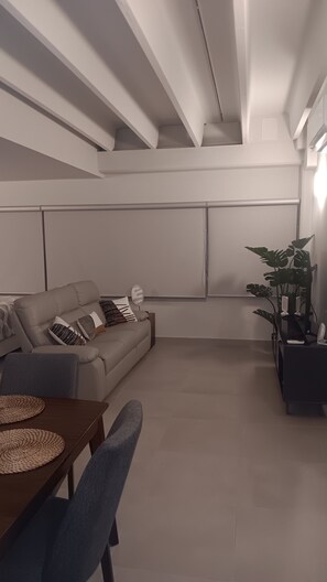 A modern living room with a sofa, a coffee table, and a dining table. - Modern Studio in San Juan, Puerto Rico (San Juan)
