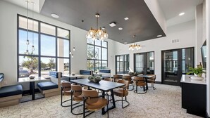 Un espace de restauration moderne, doté de hauts plafonds, de grandes fenêtres et de mobilier contemporain.