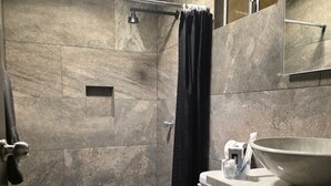 A modern bathroom with a shower, toilet, and sink area.